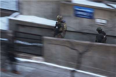 圖為聯邦移民執法人員(ICE)在拘留一名人士後離開一棟公寓大樓。(路透社/達志影像)