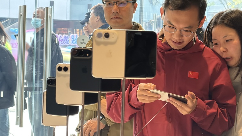 蘋果首款摺疊手機iPhone Duo 23日正式開賣。圖為北京三里屯門市的中國消費者試用新機。