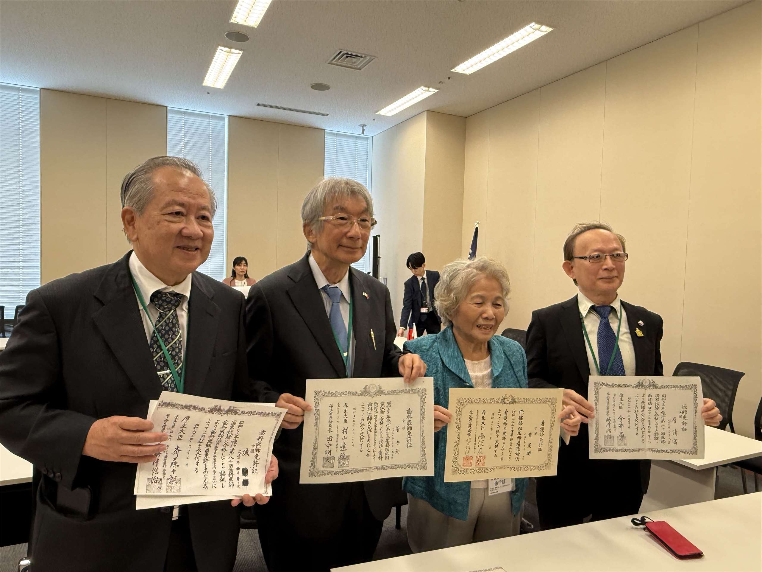 醫師陳憲文(左一)、黃世英(左二)等拿著過去登記為「中國」的國家資格證書，如今終於能改名(鄭仲嵐攝)