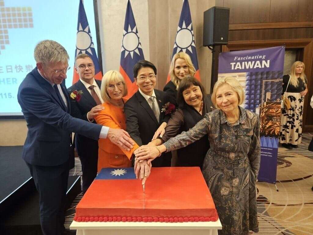 拉脫維亞國慶晚宴上，駐拉脫維亞代表陳文儀（中）邀請拉國議員一同切蛋糕慶祝。（駐拉脫維亞代表處提供）