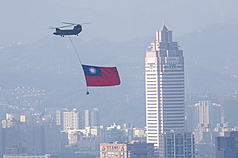 雙十國慶將至，國軍2日上午展開空中全兵力預演，陸軍CH-47SD契努克運輸直升機吊掛巨幅國旗，飛往總統府方向。