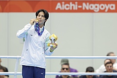 名古屋亞運女子拳擊60公斤級金牌戰2日舉行，台灣好手林郁婷拿下金牌，頒獎典禮上，林郁婷咬著金牌拍照。