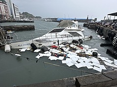 一艘停泊於小琉球白沙漁港的枋寮籍漁船，因23日晚間受強浪衝擊斷纜漂流，致船身破損，隔日凌晨進水下沉。海巡人員設攔油防線防止油污擴散。（海巡署南部分署第五岸巡隊提供）