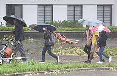 颱風薔琵減弱為輕颱，中央氣象署24日下午2時30分解除陸上警報，海警則預計傍晚至晚間解除。圖為民眾下午前往台北圓山捷運站，行經被風雨吹倒的拒馬與樹木斷枝。