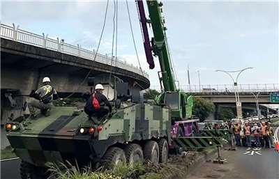 一輛軍用雲豹甲車2日清晨在新北淡水關渡大橋匝道自撞分隔島，並撞斷路燈，事故一度占用車道影響交通，目前已排除。(警方提供)
