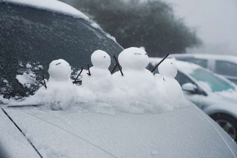 因應陽明山可能降雪 ，北市規劃3階段交管。圖為民眾在汽車擋風玻璃前堆起一排小雪人。資料照。