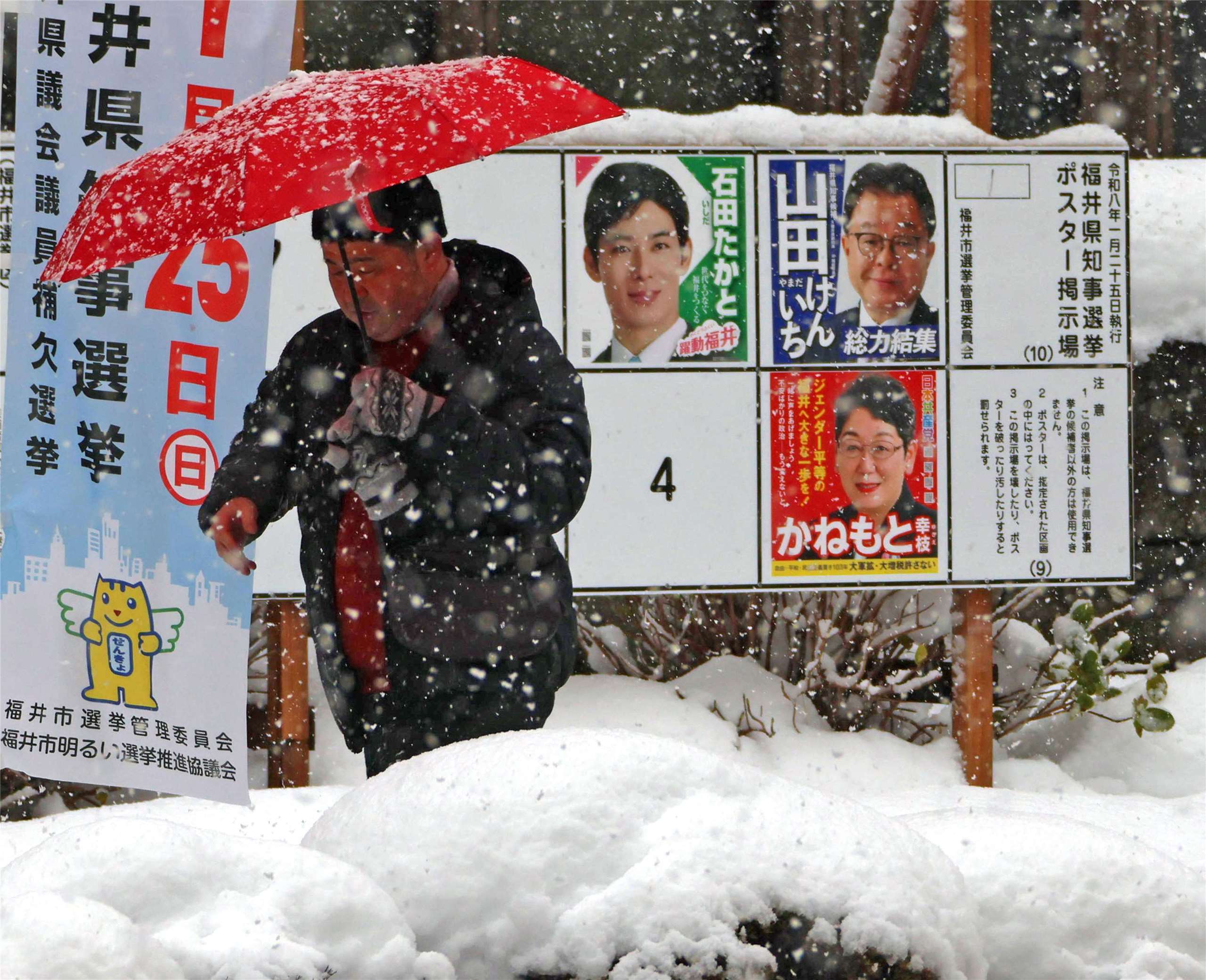日本眾議院選舉投開票今天(8日)登場，投票將在晚間 8點(台灣時間晚間7點)結束。日本福井縣福井市民眾走過眾議院選舉候選人看板。(AP/達志影像)