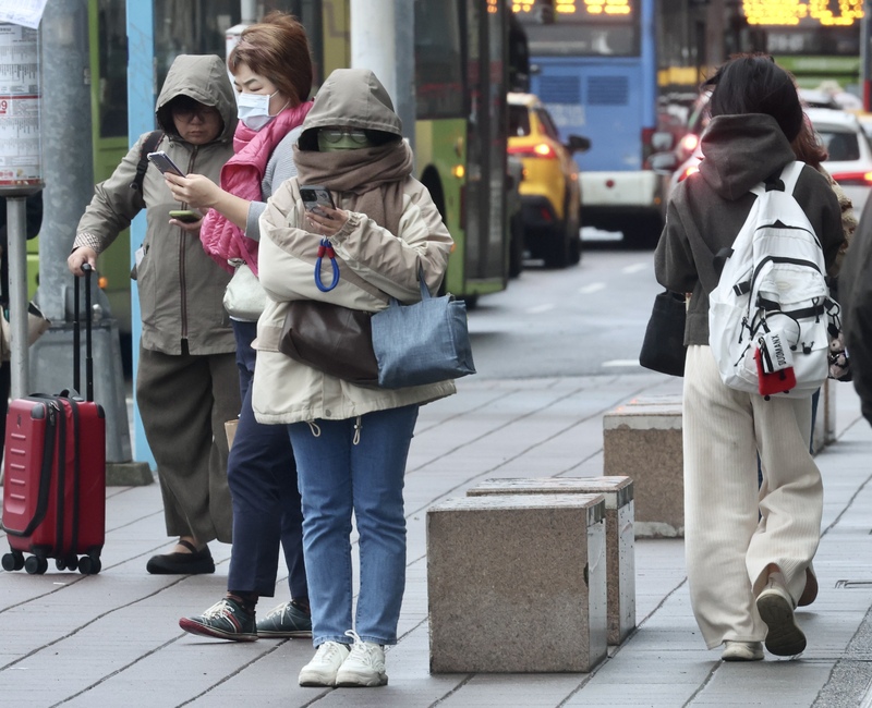 圖為民眾圍圍巾等公車。
