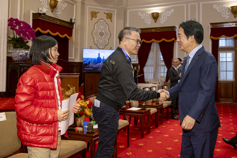 總統賴清德（右）2日在總統府接見亞太資通訊科技聯盟大賽APICTA Awards 2025獲獎代表隊，和APICTA執行委員王定愷（中）等人握手致意。
