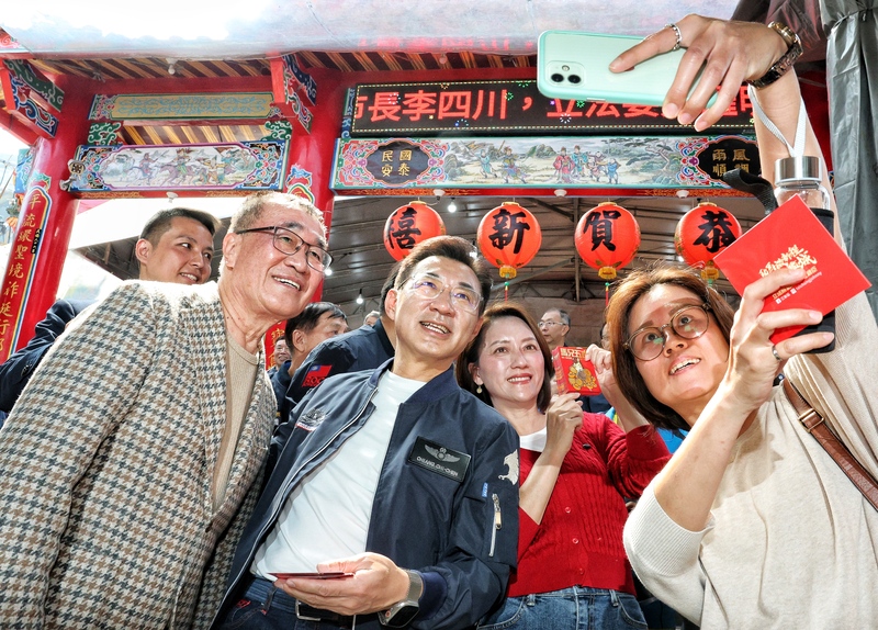 立法院副院長江啟臣（左2）偕同夫人劉姿伶（右2）與台北市副市長李四川（左）22日前往新北市新店區的太平宮參拜並發送紅包，和現場民眾自拍合影。
