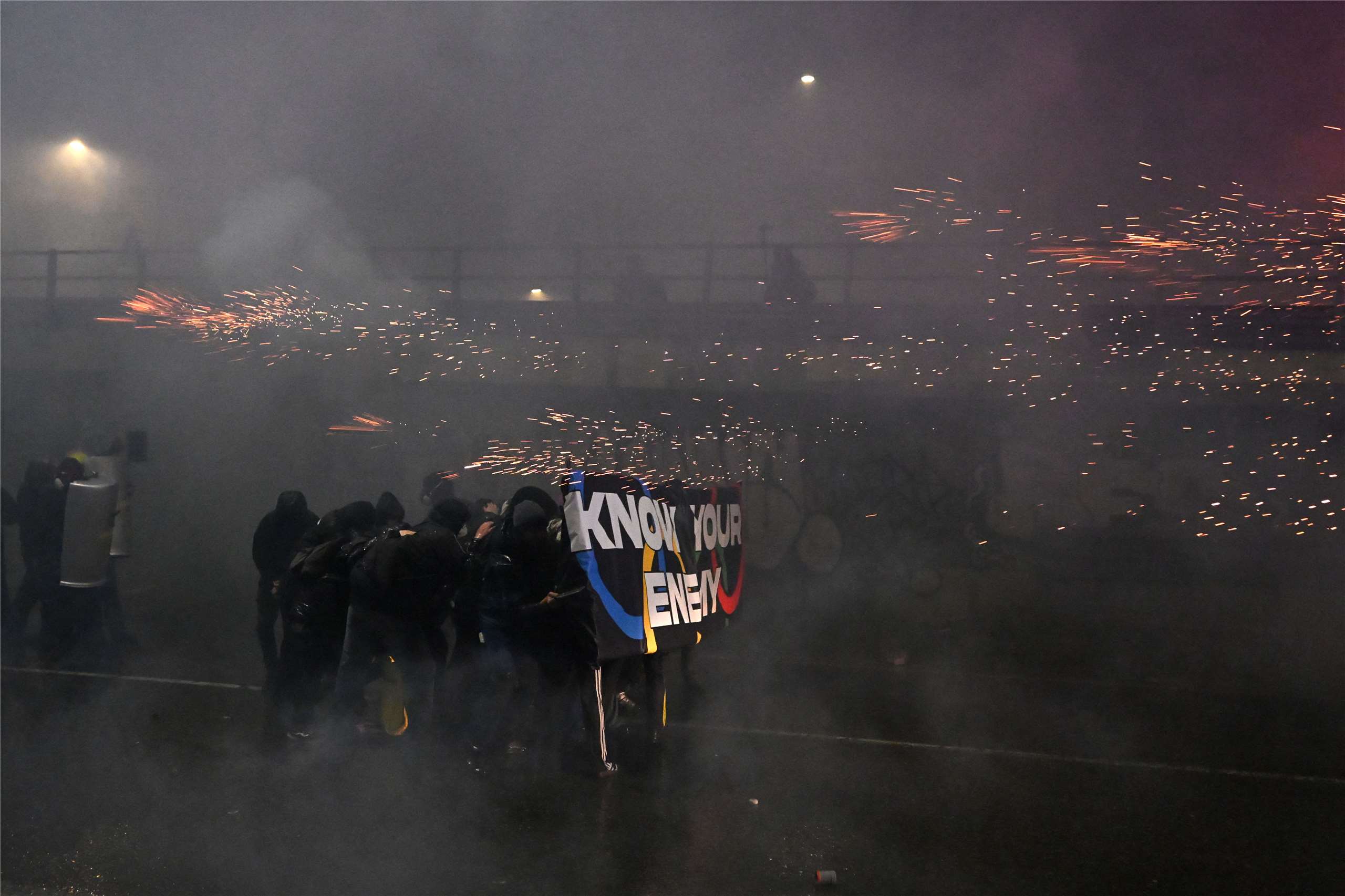 上萬民眾走上義大利米蘭街頭，抗議冬季奧運會對經濟與社會影響，期間約百人脫離主要示威隊伍，對警察投擲鞭炮、煙霧彈、瓶子和石頭等衝突事件。(AFP)
