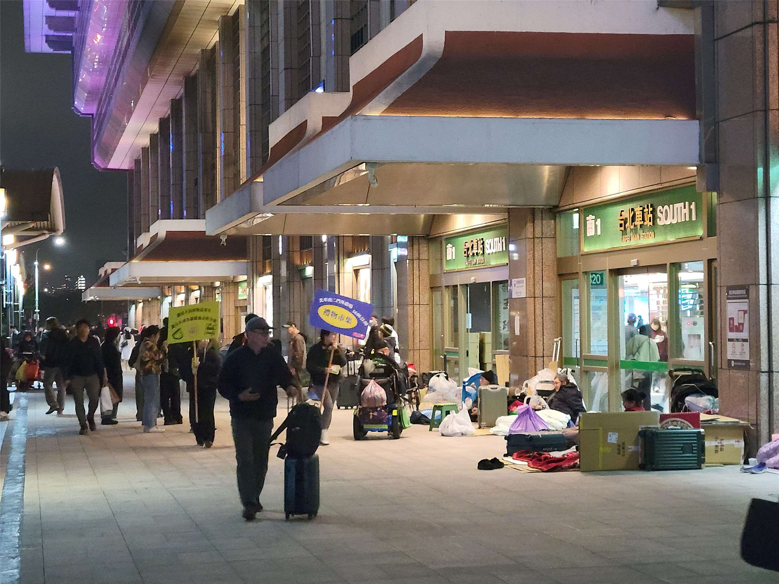 一整天工作結束，晚間無家的人聚集在台北車站外圍休息。(饒辰書 攝)