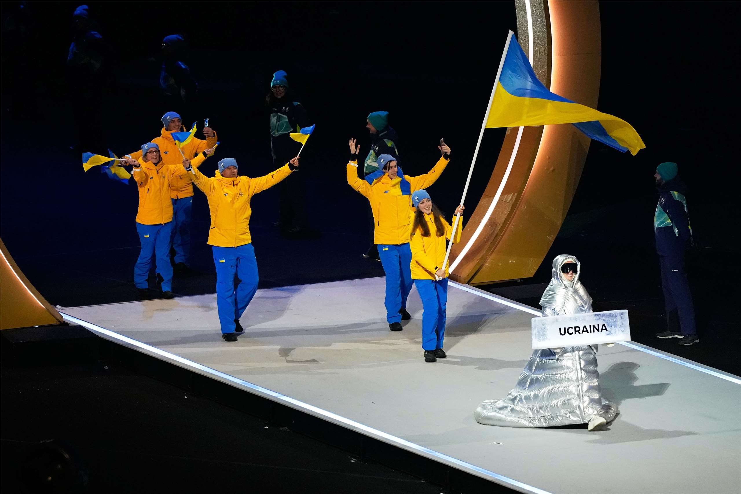 俄羅斯女子庫切羅娃(Anastasia Kucherova)(前)在米蘭冬季奧運開幕典禮上，擔任烏克蘭代表團舉牌人，以行動反對俄羅斯入侵烏克蘭。