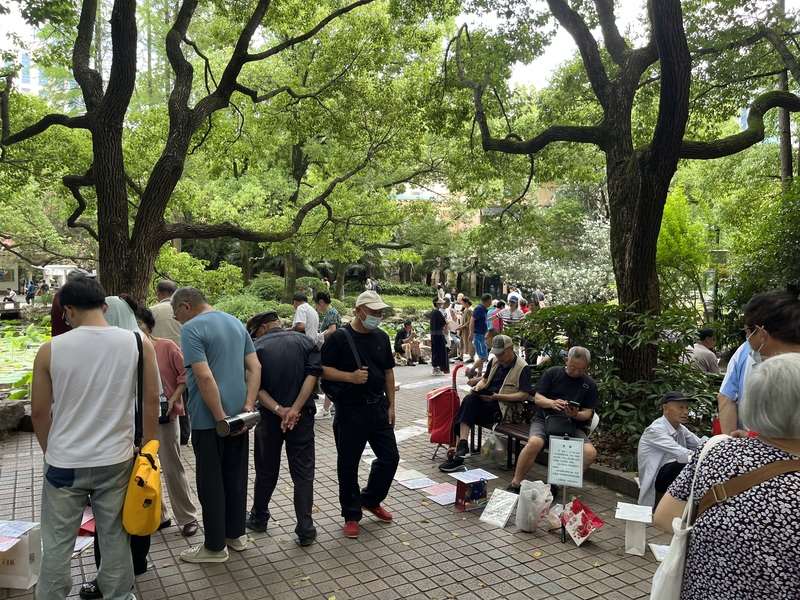 中國曾實施超過30年的一胎化政策，導致男女比例嚴重失衡，但如今卻形成了「農村男光棍」和「城市女光棍」的奇特反差。圖為上海人民公園相親角，家長在這裡公開擺出自家孩子年齡、學歷等資料，為未婚兒女找對象。(圖：中央社)