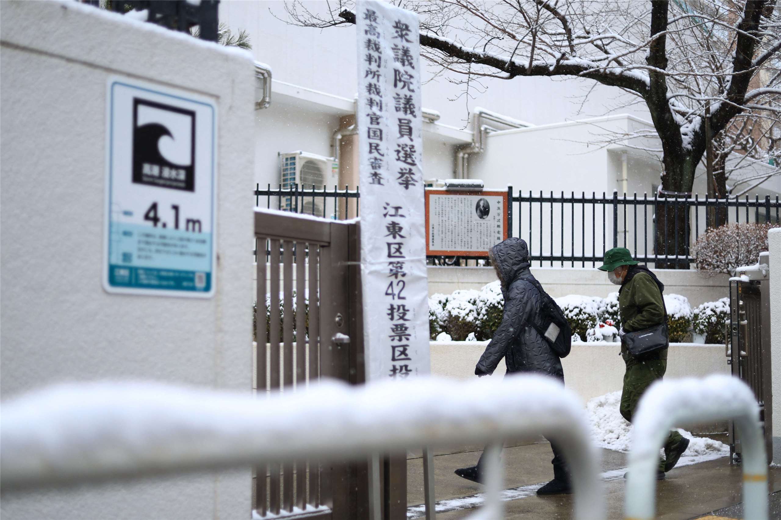 日本眾議院大選8日投票，適逢寒流來襲，東京也降下大雪，東京江東區一處投票所仍有許多民眾前往投票。(AFP)