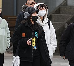 今天(8日)受到寒流影響，西半部及宜蘭低溫約攝氏8至11度，花蓮及台東12至14度，局部地區可能有10度左右或以下低溫。圖為北市中正區街頭民眾戴帽子、穿著連帽厚實衣物加強保暖。
