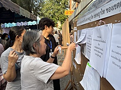 泰國8日舉行大選。在曼谷一處投票所，選務人員指引選民投票所位置。