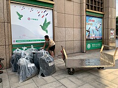 台北市社會局統計，近3年每年都成功協助約200名街友脫遊，原因之一在於對街友的要求較嚴格，有作息規定，物品還要集中管理。圖為行李房專責派工搬運街友行李。（台北市社會局提供）
