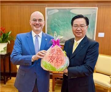 美國在台協會處長谷立言(左)今天(4日)會晤國安會秘書長吳釗燮(右)，致贈子母壽桃。(X@josephwutw)