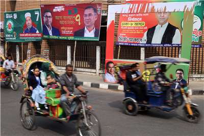 孟加拉即將舉行國內第一場大型選舉。圖攝於孟加拉達卡，車輛駛過大選前的競選橫幅。