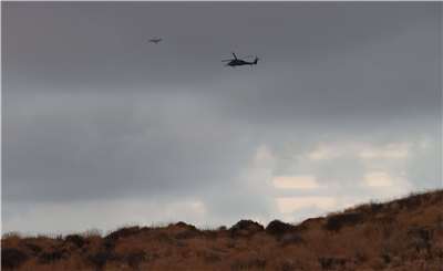 圖為熊本縣阿蘇市自衛隊直升機2026年1月20日搜尋墜毀的觀光直升機。這架失事直升機上載有一名64歲的男性飛行員和兩名台灣乘客。資料照片。