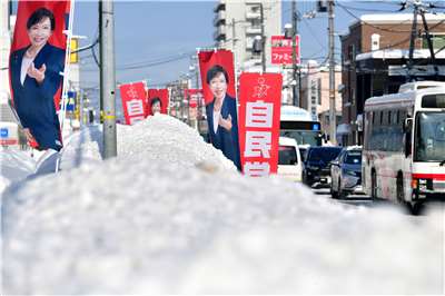 日本首相高市早苗下令解散國會後，各地區候選人展開競選活動，自民黨力拼過半席次，儘管民調領先但不敢鬆懈。圖為冰天雪地的札幌地區豎立自民黨選舉旗幟。(AP/達志影像)