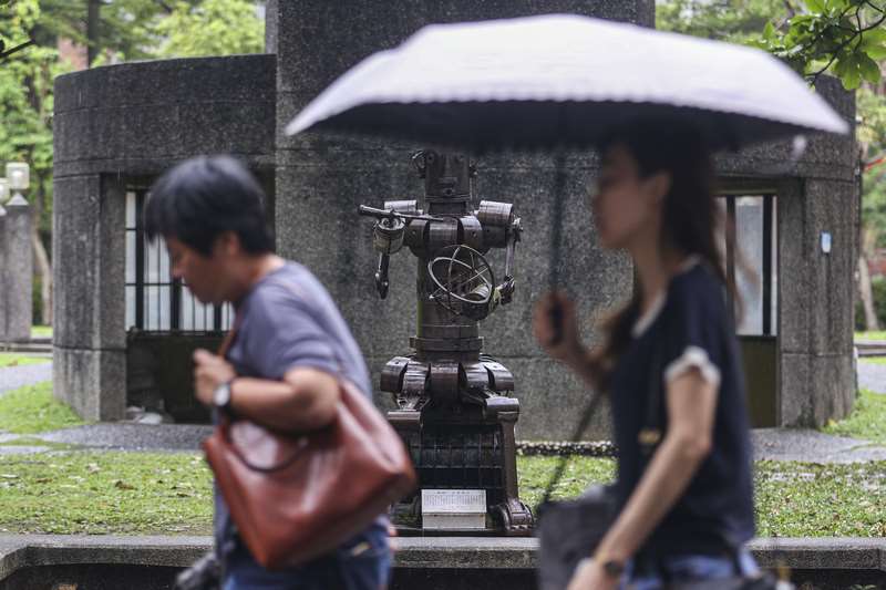 29日清晨中部以北地區有局部短暫陣雨。圖為北市民眾撐傘擋雨。資料照。