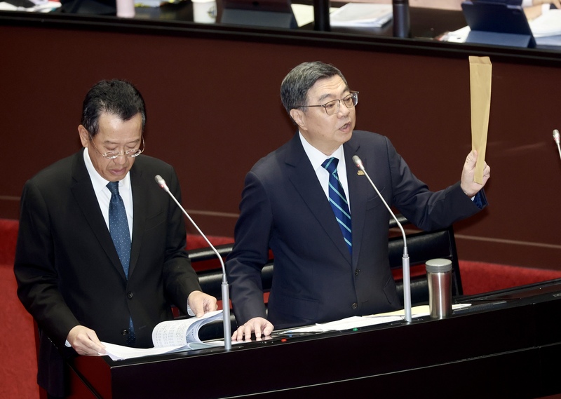 立委質疑行政院長卓榮泰包機前往日本觀看世界棒球經典賽引發爭議，卓榮泰（右）10日在立法院拿出一個牛皮紙袋表示，所有的單據連遊覽車的錢、門票的錢、單據都有，一塊錢都沒有報公費。