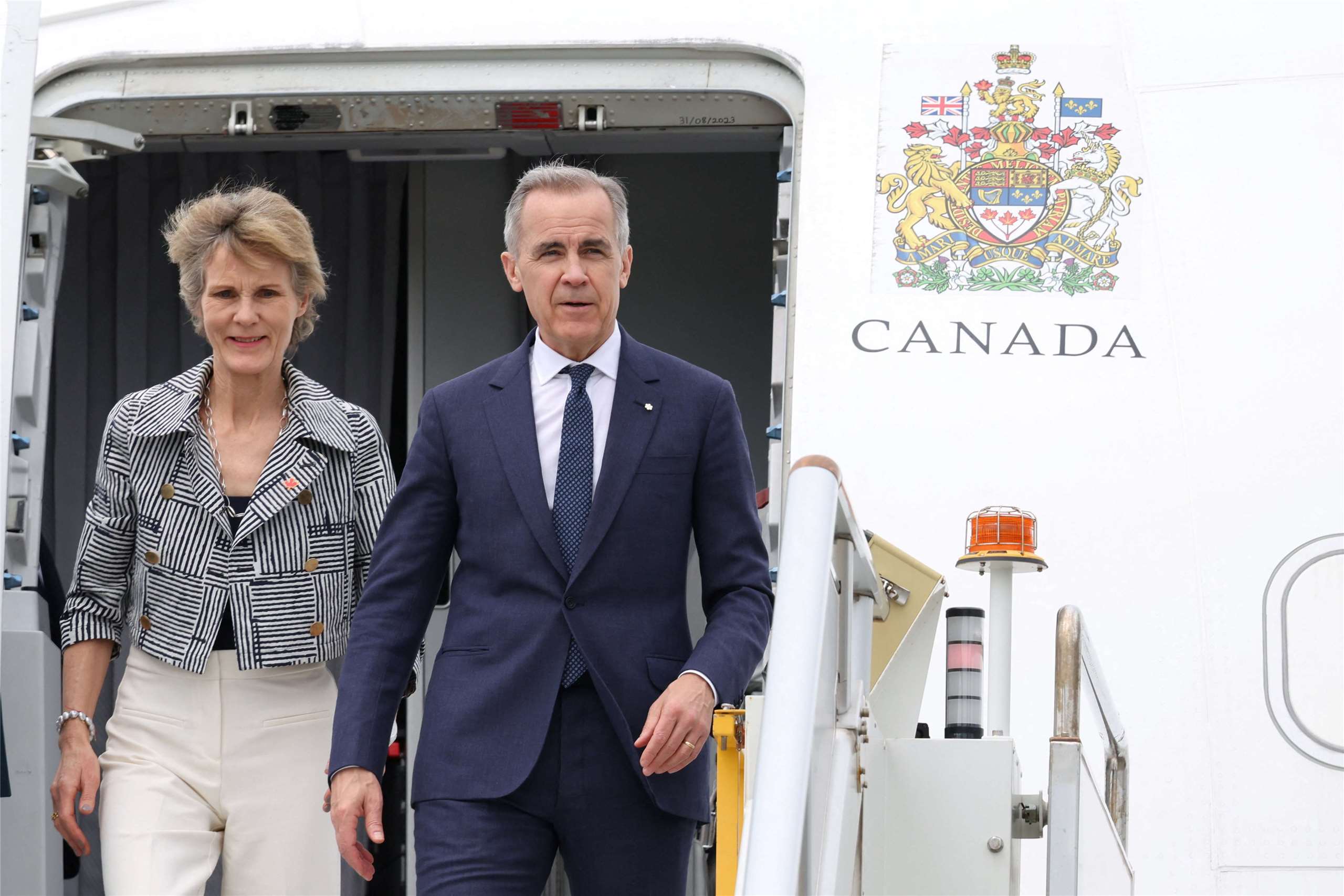 加拿大總理卡尼(Mark Carney)(右)與妻子(左)抵達雪梨。