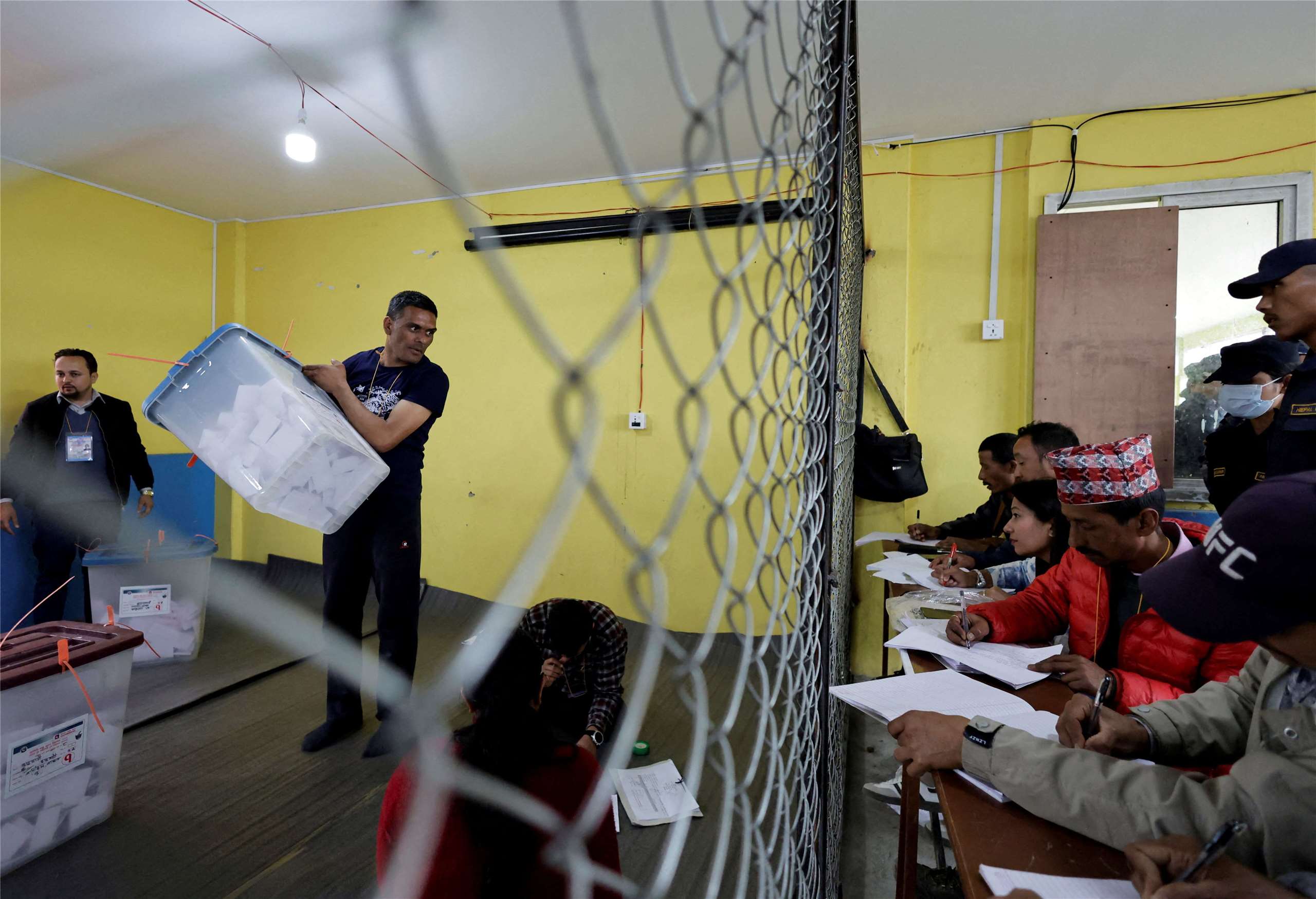 尼泊爾大選的完整開票結果預計將在一週內分曉。圖為選舉委員會官員在計票前向各黨代表展示票箱。