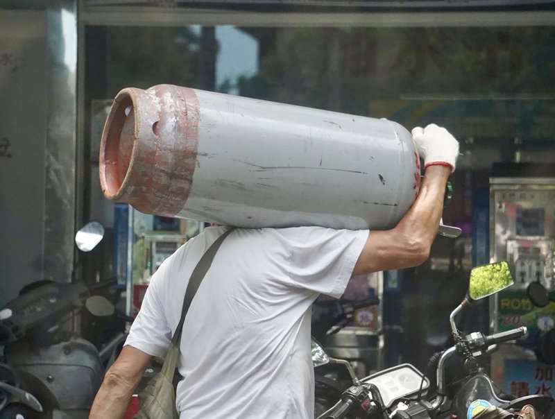 中油表示，因配合政府穩定物價政策，3月份桶裝瓦斯價格不做調整。圖為瓦斯業者將桶裝瓦斯扛在肩上搬運。