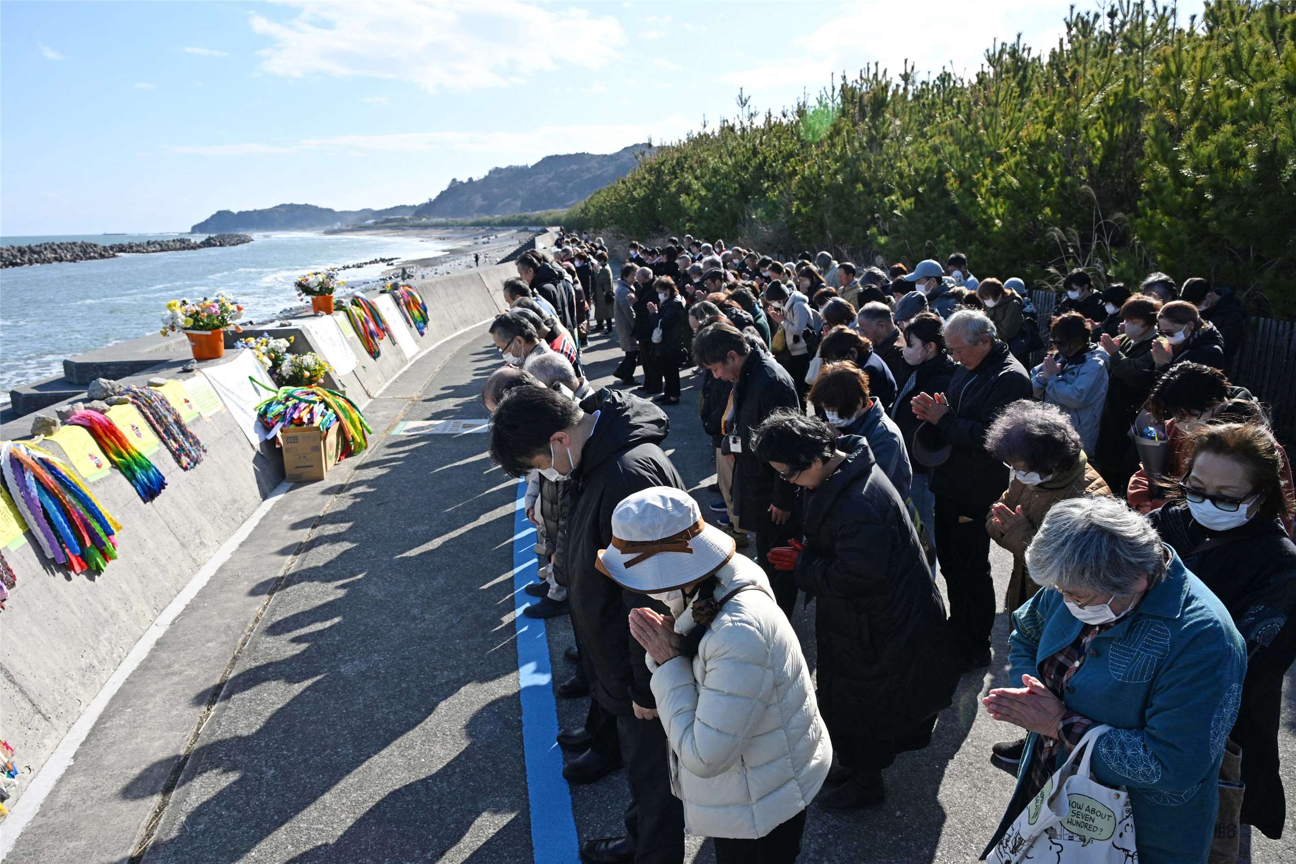 日本311地震15周年，北部福島縣磐城市民眾於11日下午2點46分(地震發生時)為地震和海嘯的遇難者祈禱。(AFP)