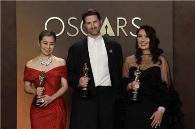 Kpop 獵魔女團獲得奧斯卡最佳動畫片獎，製作團隊上台領獎。　