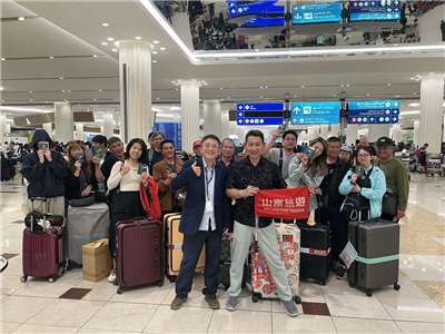 駐杜拜辦事處總領事陳俊吉(前排左)在杜拜機場慰問即將離境返台國人，並與山富旅遊團團員合影留念 (駐杜拜辦事處提供)
