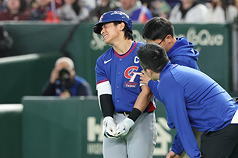 世界棒球經典賽（WBC）C組預賽5日在日本東京巨蛋開打，首戰由台灣隊迎戰澳洲隊。6局上台灣隊長陳傑憲（左）遭觸身球擊中手部，表情痛苦。(檔案照)