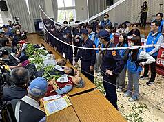 針對南投縣政府準備在名間鄉興建焚化爐一案，行政院表態希望勿犧牲農民權益。圖為南投縣環保局16日針對名間鄉焚化爐案召開二階環評範疇界定第一次延伸會議，反焚化爐自救會成員躺在桌子上，企圖阻擋開會。資料照片（名間鄉反焚化爐自救會提供）