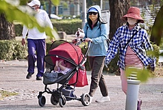 行政院拍板通過勞動部放寬外籍幫傭申請資格，家中育有一名未滿12歲的孩童即可提出申請，並自4月13日起開放受理。圖為民眾推著嬰兒車外出散步。資料照。
