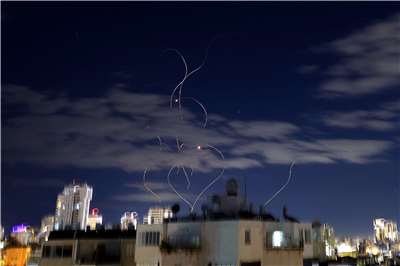 伊朗對以色列發動飛彈襲擊。圖為以國上空出現的飛彈尾跡。(AFP)