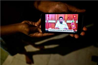 民眾5日在手機觀看斯里蘭卡總統迪桑納亞克（Anura Kumara Dissanayake）發表全國演說。