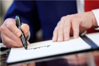 美國總統川普的簽名將出現在新版美鈔上。圖為川普在政府文件上簽名。 (路透社/達志影像)