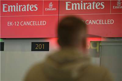 國際航空樞紐杜拜在內的許多個中東主要機場，28日均被迫關閉，乘客觀看阿聯酋航空航班取消告示牌。(AFP)