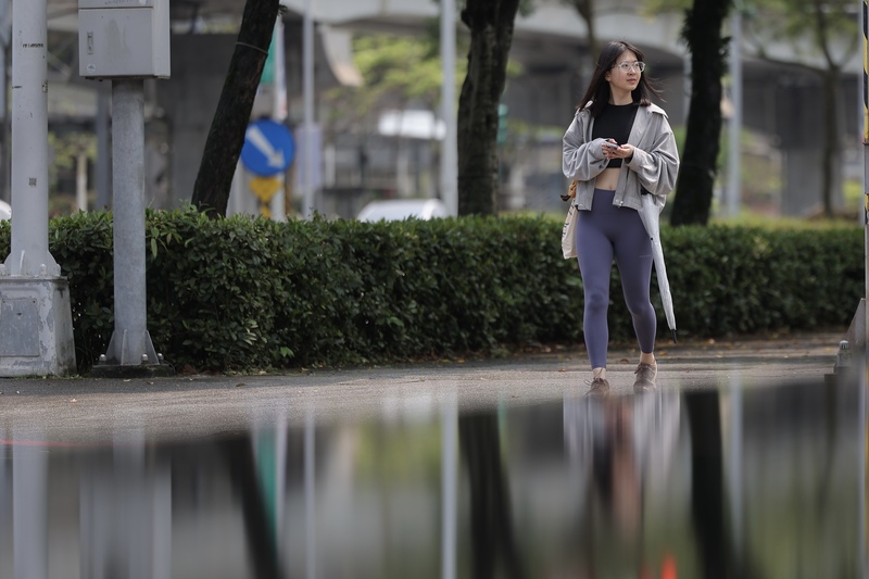 中央氣象署12日表示，未來一週有兩波微弱鋒面接力，北部、東半部易有短暫陣雨、氣溫略降。圖為民眾帶傘出門以防下雨。