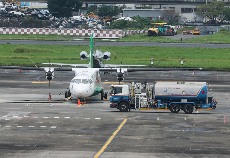 受到中東戰火衝擊油價攀高，交通部估算整體海陸空運用油補貼恐達新台幣85億元。圖為松山機場一輛油罐車行經立榮航空班機前。(中央社)