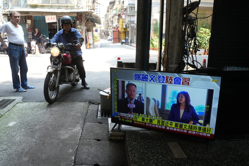 國民黨主席鄭麗文10日在北京人民大會堂東大廳與中共總書記習近平會面。圖為台北市萬華區民眾關注相關新聞。