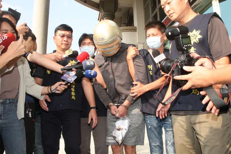 梁育誌殺馬來西亞女大生命案， 最高法院判處無期徒刑定讞。圖為2020年10月梁育誌（中）訊後被警方帶出警局移送地檢署，面對大批媒體詢問，梁育誌低頭不發一語。（中央社檔案照片）