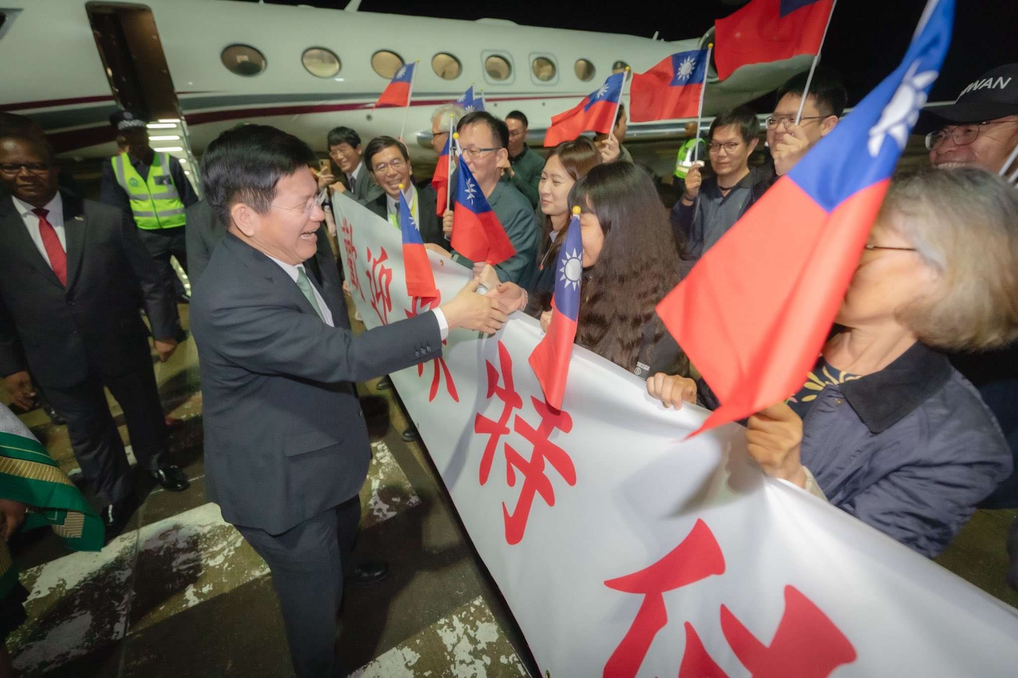 外交部長林佳龍擔任總統特使抵達史瓦帝尼，我國大使館人員、技術團與僑胞深夜仍熱情揮舞國旗、高喊歡迎。(圖取自林佳龍臉書)