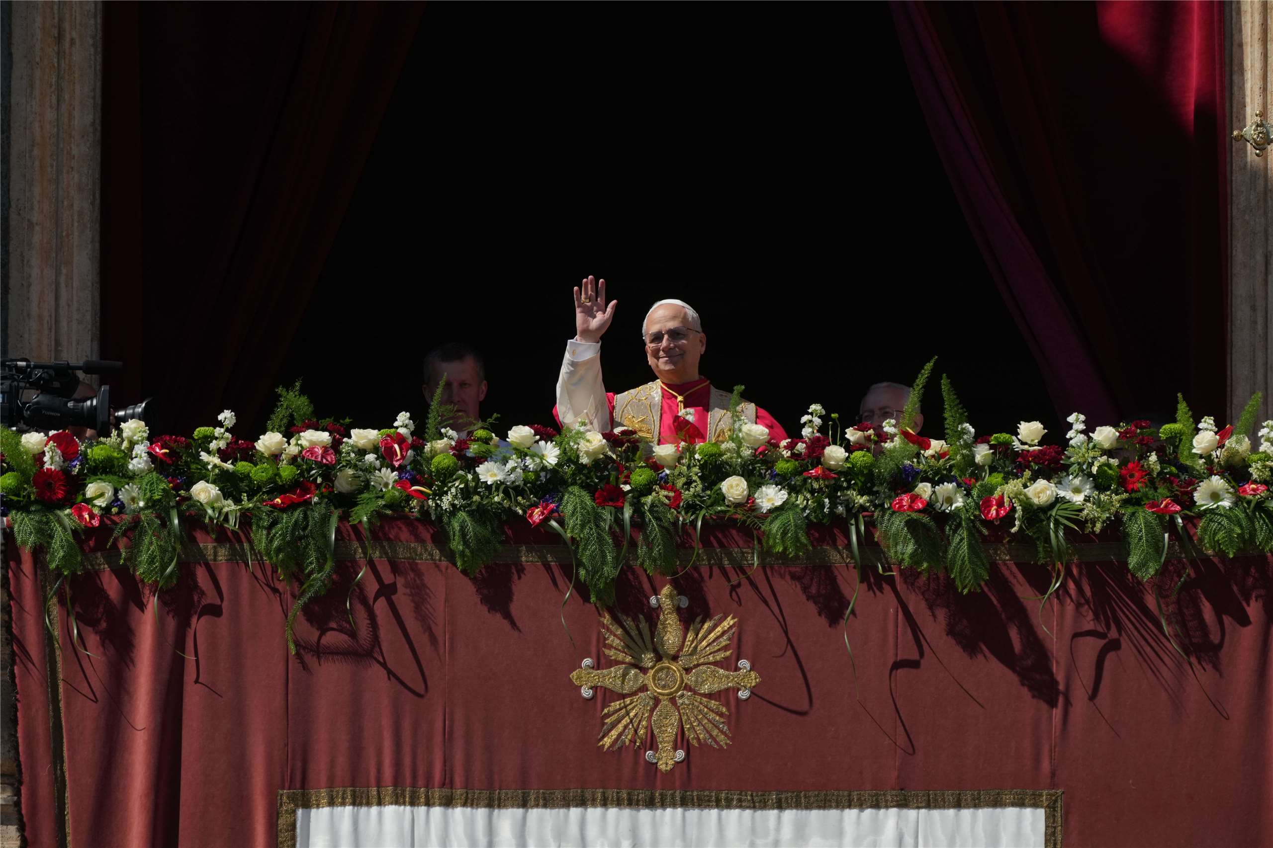 教宗良十四世站在眾多花朵裝飾的梵蒂岡聖伯多祿大殿上，對底下廣場的數萬名信眾發表「致全城與全球」(Urbi et Orbi)文告。