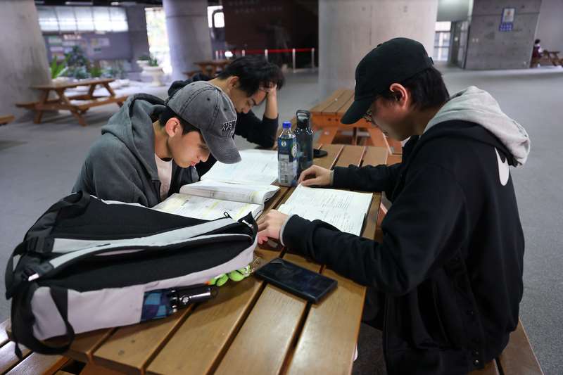 115學年度技專統測將於25日、26日舉行，預計有7.1萬人應試(含二技)。圖為往年考生在考場把握時間複習資料照。(圖：中央社)