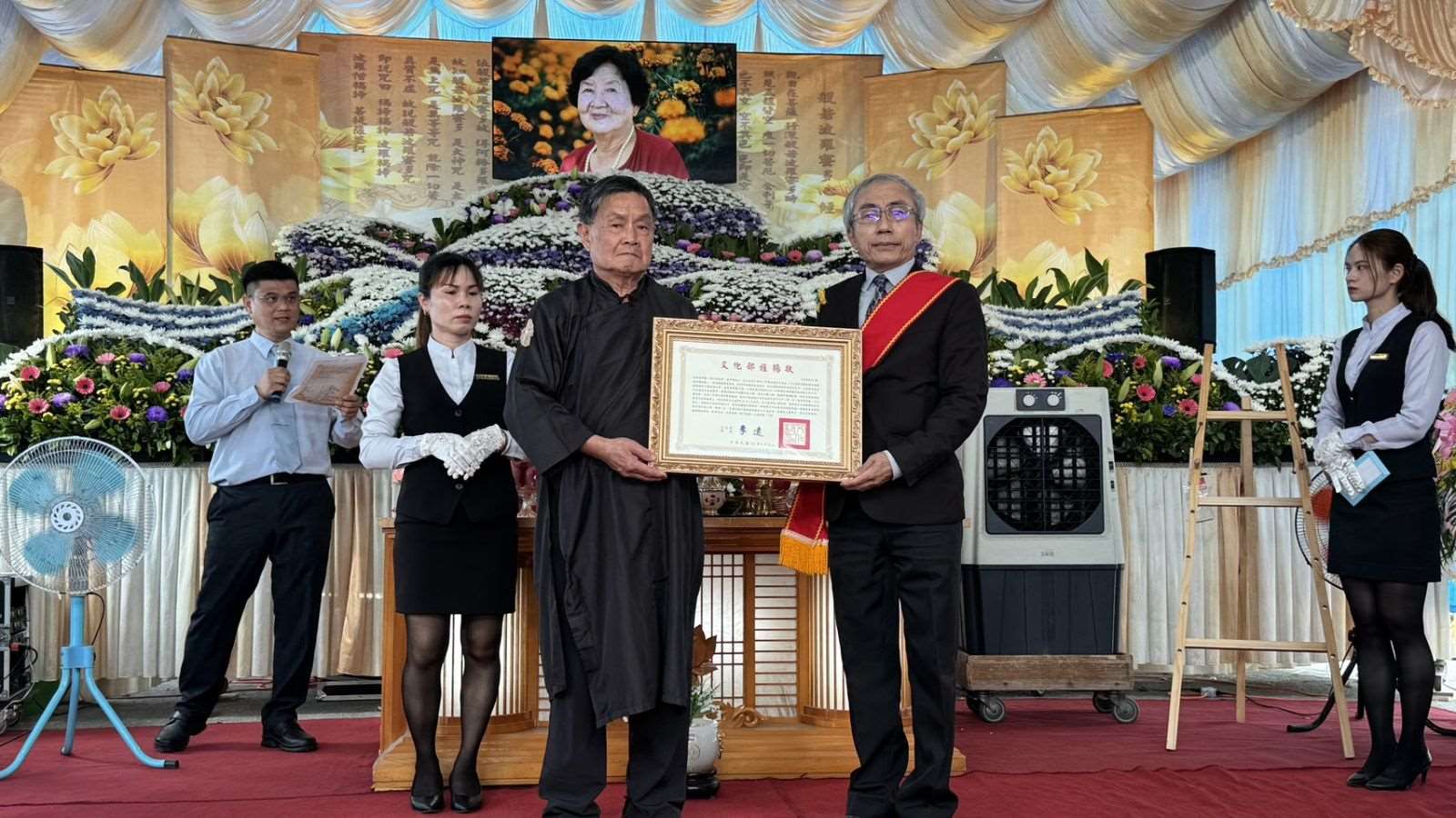 台東縣傳統工藝「台東藺草編」保存者林黃嬌辭世 ，文化部文資局長陳濟民(右)代表頒贈文化部旌揚狀，由林黃嬌兒子林瑞庭(左)代表受贈。(文資局提供)