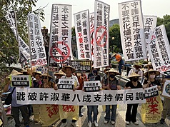 南投縣政府擬在名間鄉新民村興建垃圾處理及再生能源中心，15日舉行二階環評範疇界定會議，居民在場外拉白布條表達反對立場。